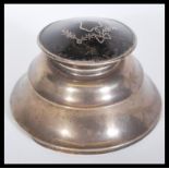 An early 20th Century silver hallmarked inkwell having a tortoiseshell lid and ribbon decoration.