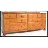 An antique style Victoria range Ducal country pine double chest of drawers raised on bun feet.