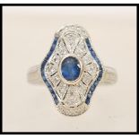 A 1920's 18ct white gold art deco panel ring set with a central oval cut sapphire in a shaped