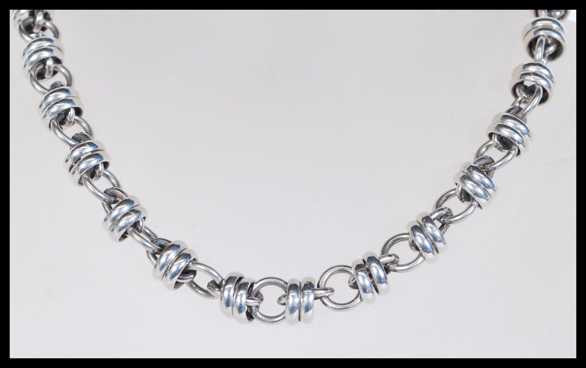A silver necklace with circular links having a toggle clasp. Total weight 76g.