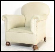 A late 19th early 20th Century armchair in the manner of Howard and Sons, barrell arms raised on cup