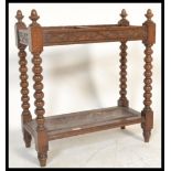 An early 20th Century Edwardian stick stand oak, the twin division with carved rails on turned