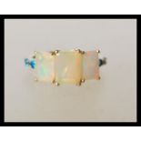 A hallmarked 9ct / 10k stamped gold opal and topaz ring having three square cut opal panels