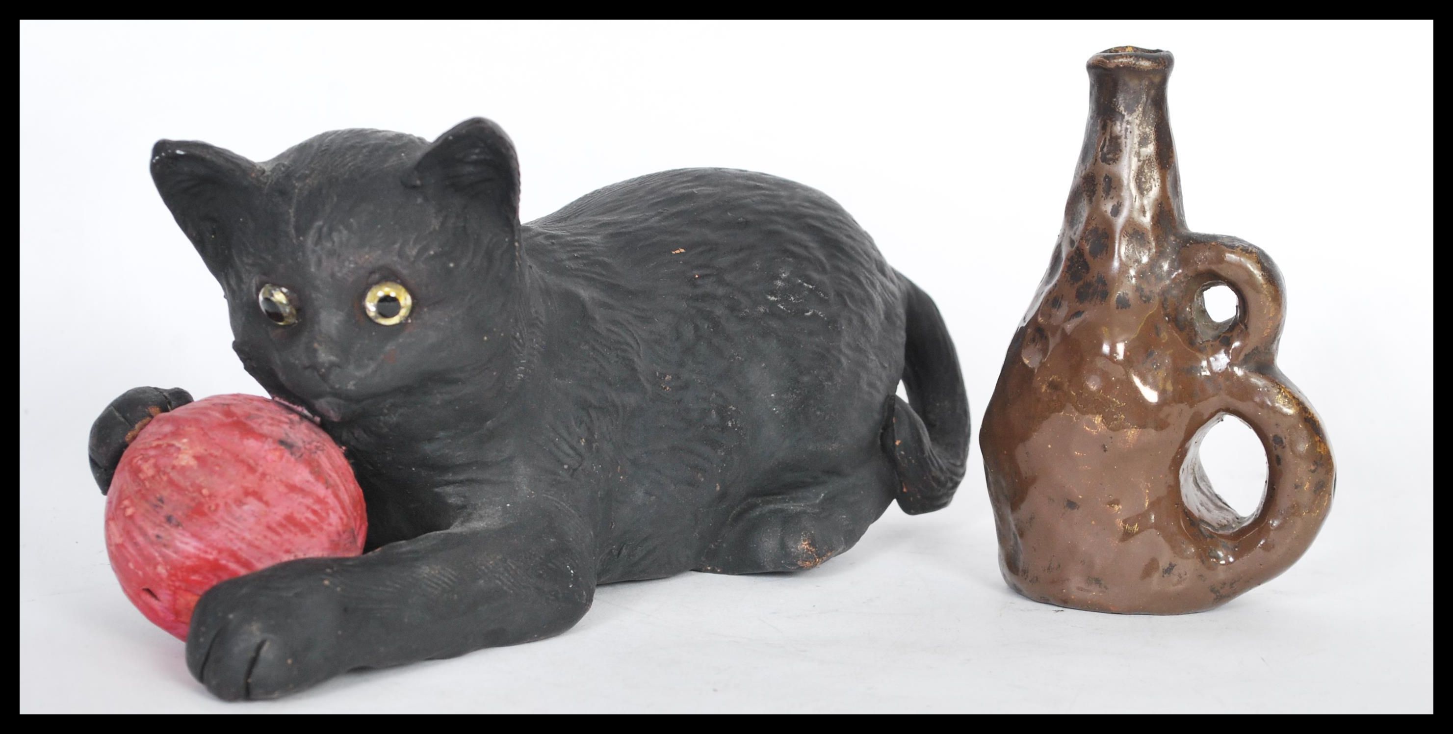 A Bretby figurine in the form of a cat with a ball of pink yarn no. 1618 and a smaller art pottery