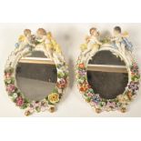 A PAIR OF GERMAN SITZENDORF PORCELAIN CHERUB BARBOLA MIRRORS