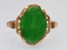 A Victorian gold and Jadeite ring. The ring having an oval green jade panel having raised shoulders.
