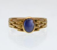 AN 18CT GOLD AND STAR CABOCHON CUT SAPPHIRE LADIES RING