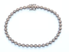 A hallmarked 18ct white gold and diamond tennis line bracelet. The bracelet being set with 41