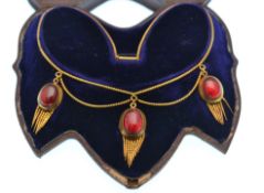 A Victorian gold and garnet Etruscan revival locket tassel necklace in fitted case. The necklace