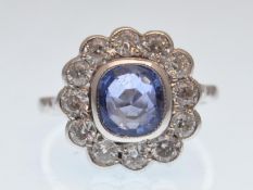 An impressive 18ct white gold sapphire and diamond flower ring. The central cushion cut sapphire