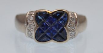 An 18ct gold sapphire and diamond ring. The ring having fancy cut blue sapphires set in a kiss motif