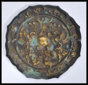 A Chinese 19th Century bronze mirror having emboss