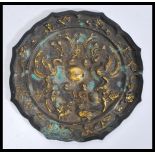 A Chinese 19th Century bronze mirror having emboss