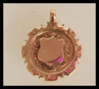 A hallmarked 9ct gold medal pendant having an unma