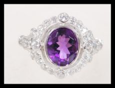 A sterling silver CZ and amethyst ring having a ce