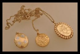 A group of three 9ct gold locket pendants two bein