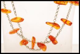 A long amber beaded necklace spaced with a silver