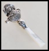 A sterling silver babies rattle in the form of a l