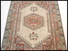 A 20th Century Persian Islamic rug having a red gr