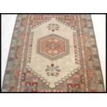 A 20th Century Persian Islamic rug having a red gr