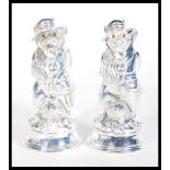 A pair of white metal novelty condiments in the fo