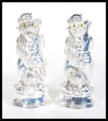 A pair of white metal novelty condiments in the fo