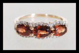 A hallmarked 9ct gold diamond and orange stone rin