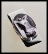 A silver novelty money clip depicting an erotic sc