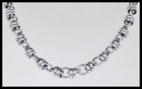 A silver necklace with circular links having a tog