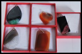 A selection of polished stone pendants on white me