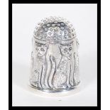 A sterling silver thimble having relief decoration