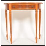 A 20th Century Regency style demi-lune side table having a bow front and single drawer with swing