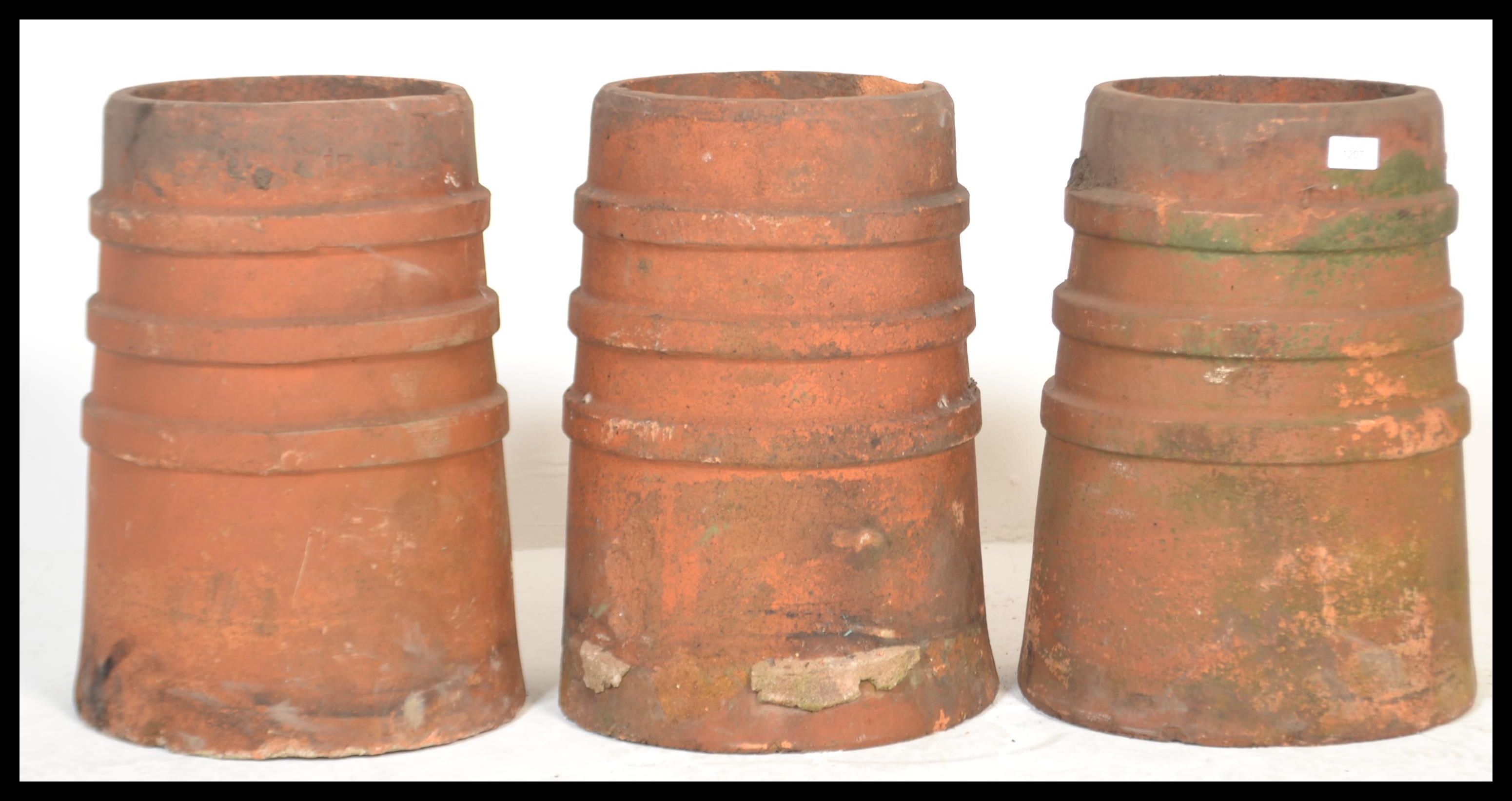 A group of three 20th Century reclaimed stoneware chimney pots of matching cylindrical form.