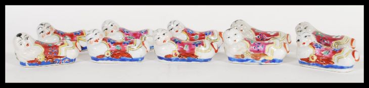 A set of ten ceramic chopstick rests in the form of Chinese opium pillow headrests hand decorated in
