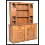 A 19th Century Victorian oak kitchen dresser having a wide base comprising a series of drawers and