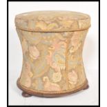A 19th Century mahogany based pinched cylinder ottoman stool of wasted form having floral chintz