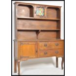 A 1920's Arts & Crafts revival oak dresser having coloured leaded glass cabinet to the centre of the