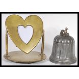 A 20th Century brass trench art swing photo frame in the form of a heart raised on a round base