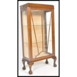 A mid 20th Century mahogany Queen Anne revival upright display cabinet bookcase raised on ball and