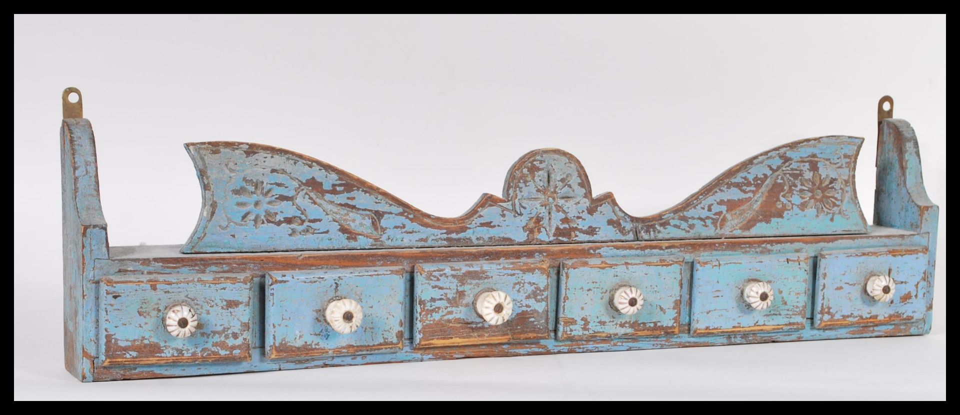 A vintage 20th Century wall hanging painted distressed pine spice shelf. The shelf having a run of