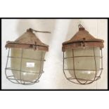 A pair of vintage / retro  20th Century industrial factory bulkhead cage lights, having a cast body,