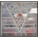 An early 20th Century leaded stain glass window having a geometric triangular design made up of