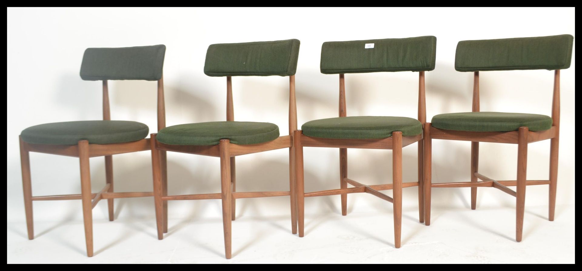 A set of four teak G-plan dining chairs designed by Koford Larsen. Raised on tapered turned legs