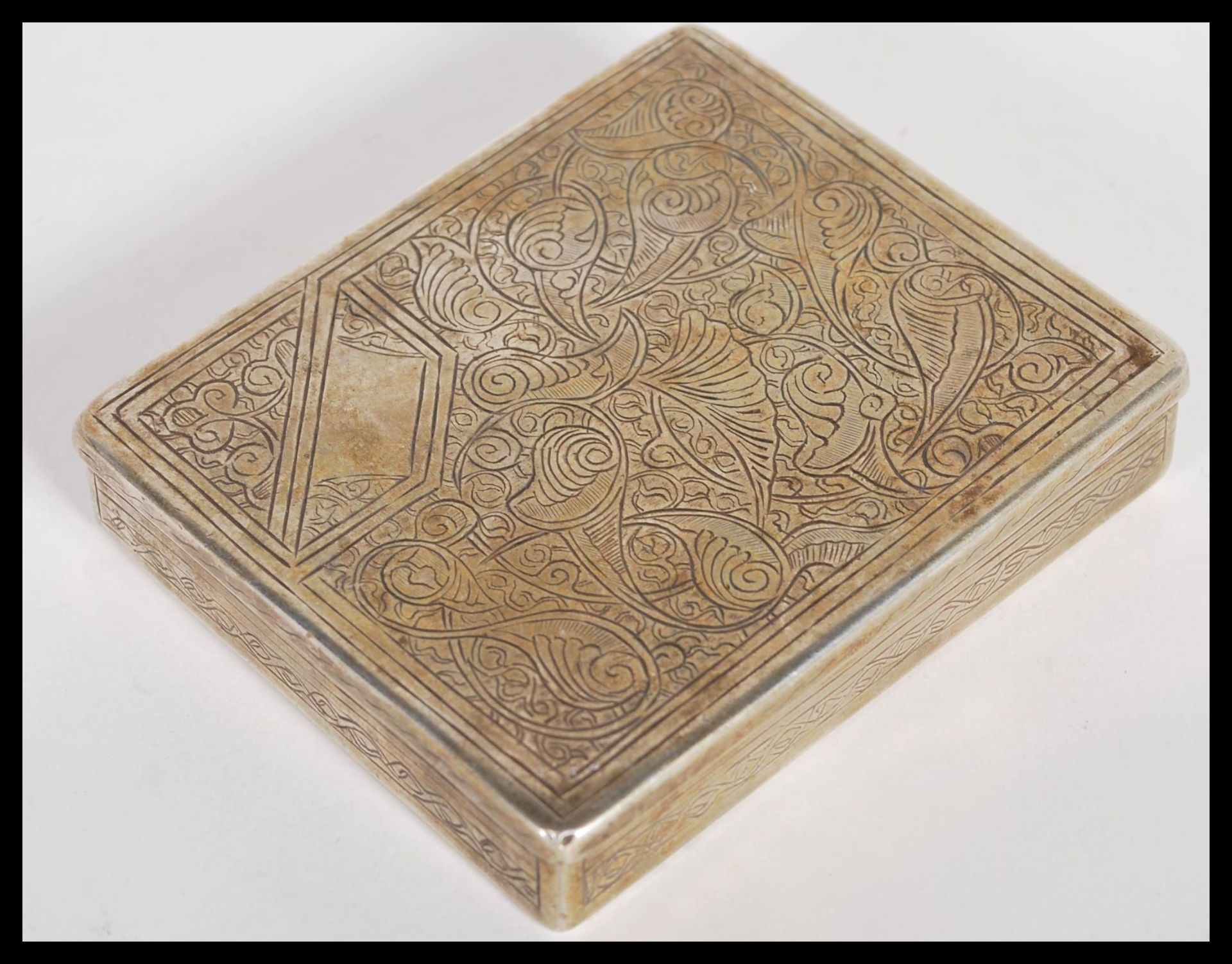 An early 20th Century Islamic silver box having scrolled engraved design. Weighs 115.7 grams. H2cm x