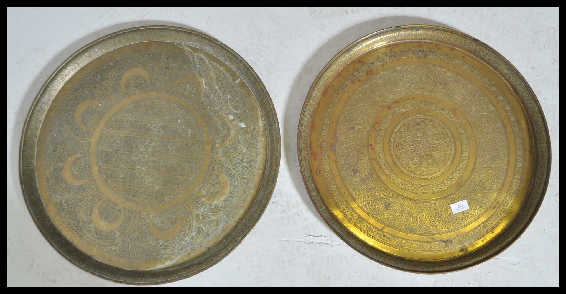 A pair of early 20th Century Persian Islamic brass charger plates of circular form having leaf and