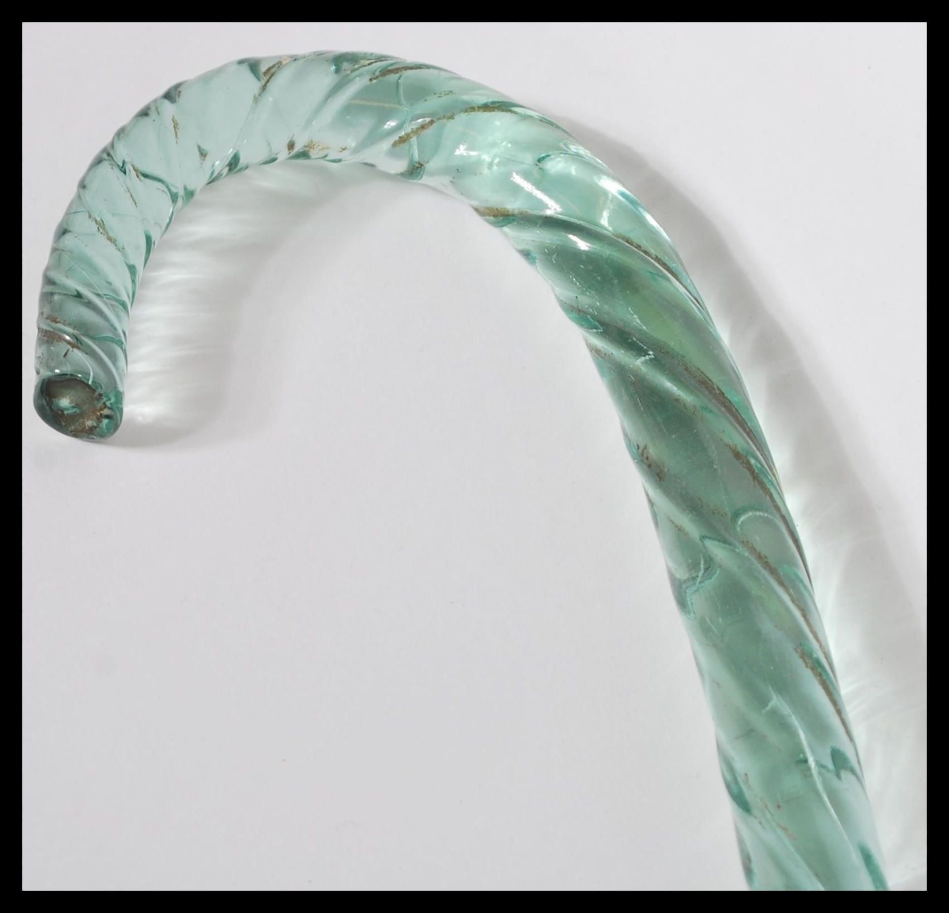 A 19th Century Nailsea glass walking stick of shaped tapering form having a twisted design.