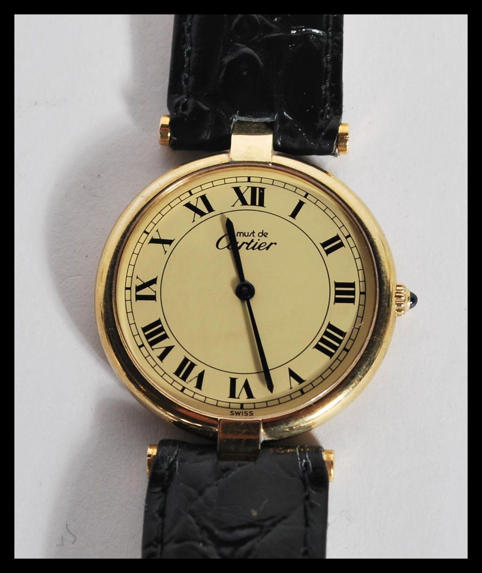A vintage Must de Cartier wrist watch having a round face with roman numerals to the chapter ring