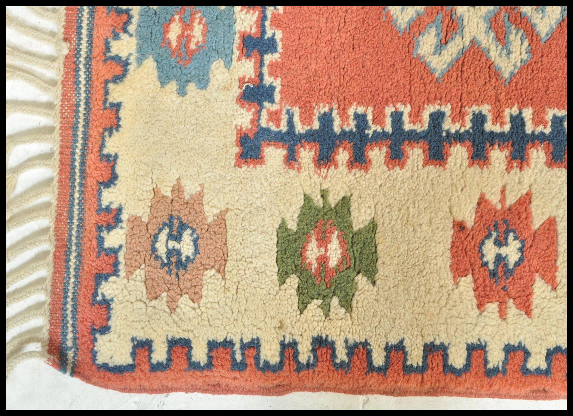 A 20th Century woven tribal carpet rug having a cream ground with a central red panel with three - Bild 3 aus 4