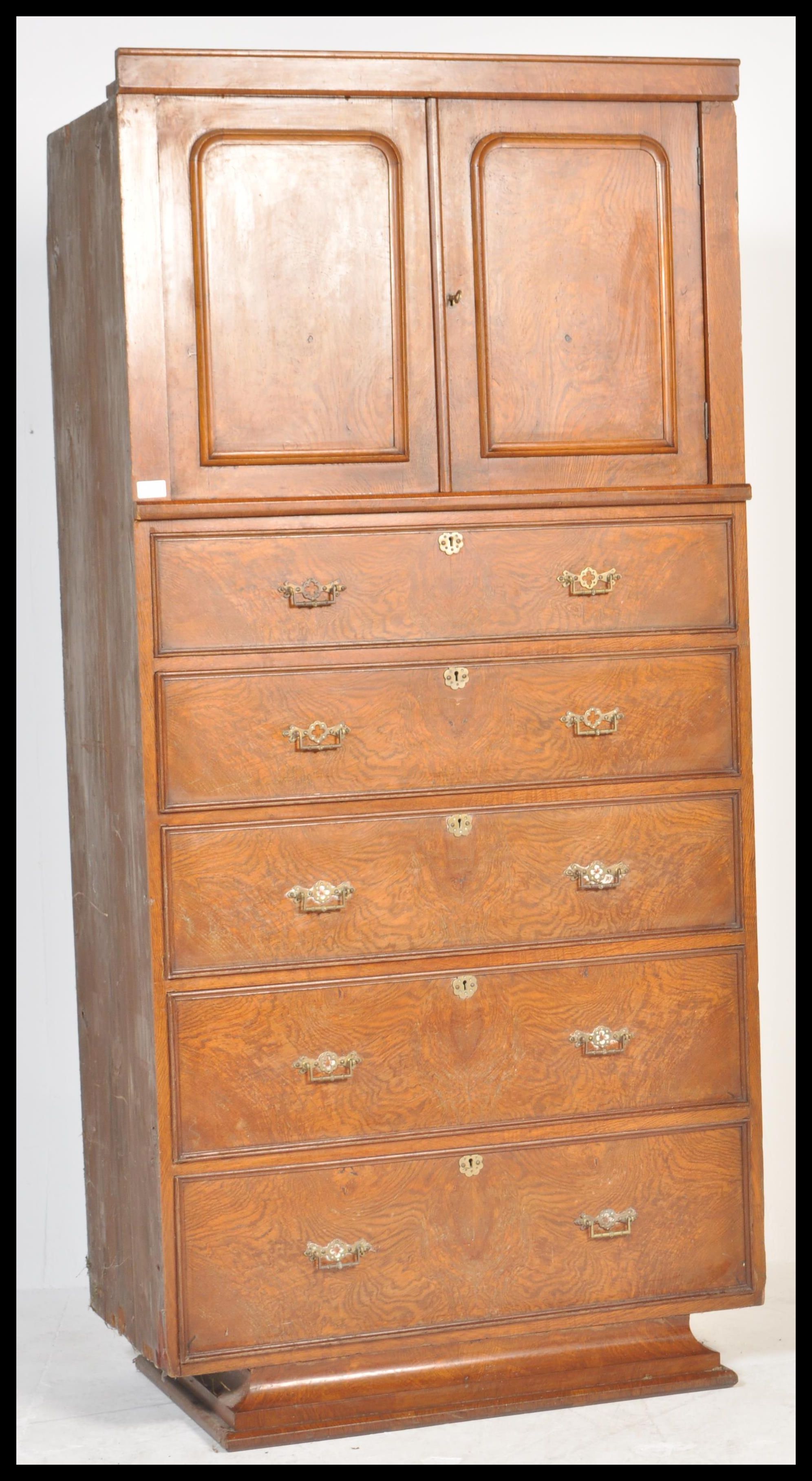 A late 19th Century Victorian walnut tall chest of five graduating drawers below twin cupboard to