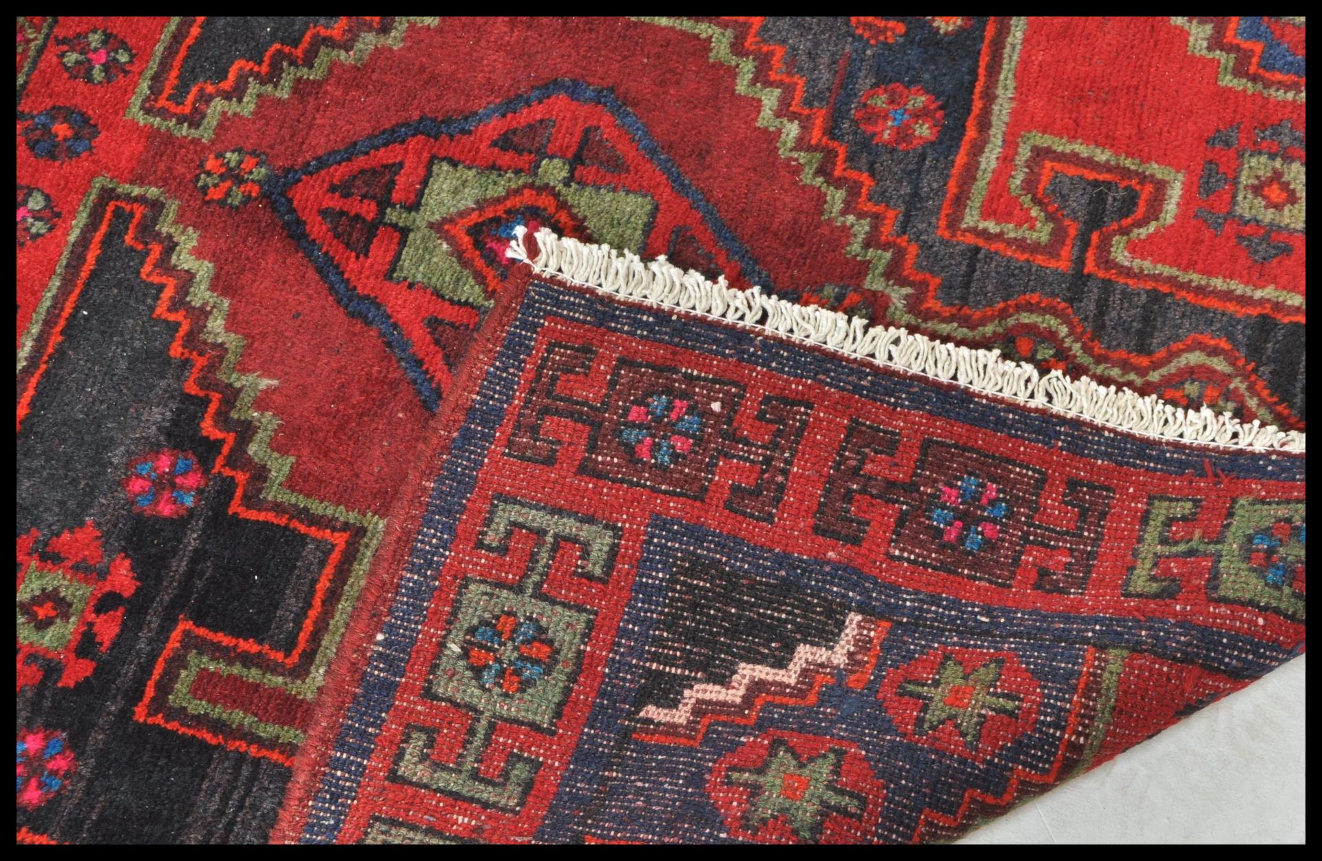 A Persian Islamic tribal Bakhtiari hand made wool rug / floor carpet having a red ground with - Bild 4 aus 4